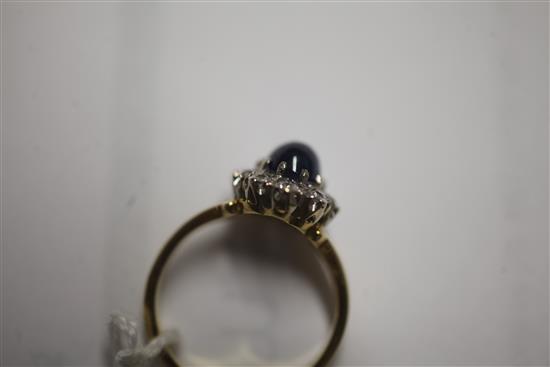 A cabochon sapphire and diamond cluster ring, size N.